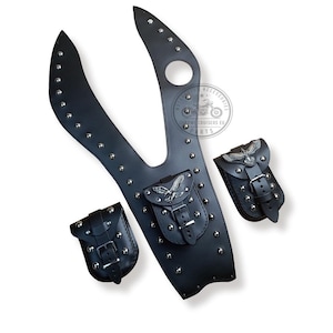 May include: Black leather motorcycle saddlebags with studded detailing and eagle accents. The saddlebags have buckles and straps for attaching to a motorcycle.