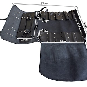 May include: A dark gray leather tool roll with multiple pockets and straps. The tool roll measures 77 cm long and 48 cm high when open. It features a handle, a pocket that is 14 cm wide, and several smaller pockets.