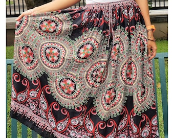 May include: A long black skirt with a colorful paisley print. The skirt has a drawstring waist and a flowing silhouette.