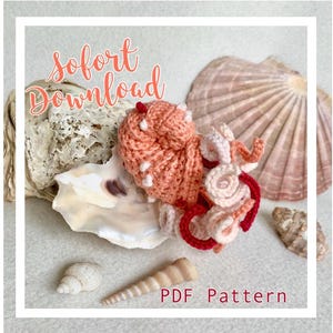 May include: A crocheted amigurumi sea creature in shades of pink and red, with the text "sofort Download PDF Pattern" on a white background.