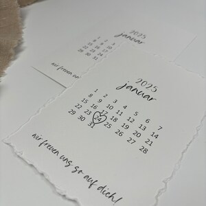 K&ouml;nnte beinhalten: Eine wei&szlig;e Karte mit einem Kalender f&uuml;r Januar 2025. Der 24. ist mit einem Herzen umkreist. Der Text "wir freuen uns so auf dich!" steht unter dem Kalender.