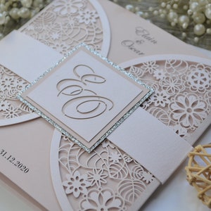 Laser cut wedding invitation in blush pink colour. Laser cut initials added at the front on the silver glittery background.