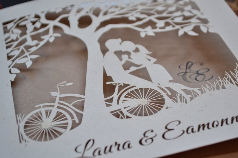 laser cut invitation with bike and couple under the tree.