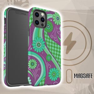 May include: A phone case with a vibrant floral design. The case features a purple background with green and teal flowers and wavy patterns. The phone case is shown next to a charging symbol with the word "MAGSAFE".