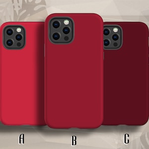 May include: Three phone cases in different shades of red. The cases all share the same design, with a raised camera bump and a smooth, matte finish. The cases are labelled A, B, and C.