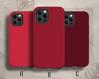 May include: Three phone cases in different shades of red. The cases all share the same design, with a raised camera bump and a smooth, matte finish. The cases are labelled A, B, and C.