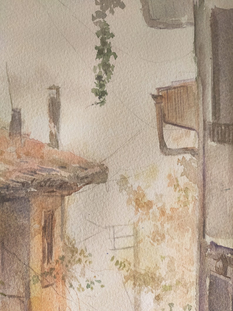 May include: Watercolor painting of a European street scene. The artwork depicts buildings with terracotta roofs, a window, and hanging greenery. The color palette includes warm tones of brown, beige, and green, creating a vintage aesthetic.