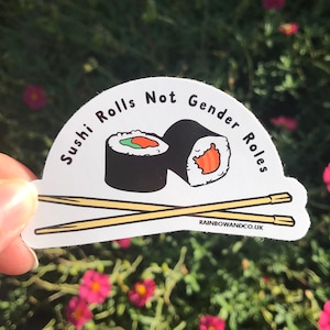 May include: White sticker with a black outline in the shape of a half-circle. The sticker features two sushi rolls with chopsticks and the text "Sushi Rolls Not Gender Roles".