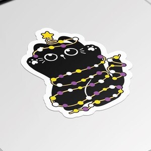 May include: Black cat with yellow and purple lights wrapped around it, with a star on top of its head.