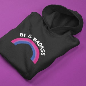 May include: Black hoodie with a rainbow graphic and the text "Bi & Badass" in white.