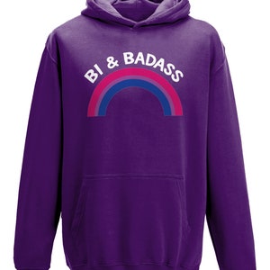 May include: Purple hooded sweatshirt with a rainbow and the text "Bi & Badass" in white.
