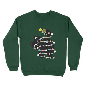 May include: A dark green sweatshirt with a black cat wrapped in colorful Christmas lights. The cat is looking to the left and has a star on its head.
