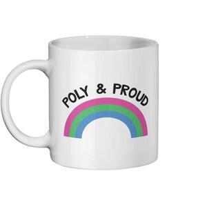 May include: White ceramic mug with a rainbow design and the text "POLY & PROUD" in black.