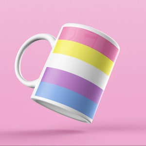 May include: White ceramic mug with a pink, yellow, white, purple, and blue striped design. The mug is on a pink background.