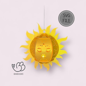 May include: A yellow papercraft sun lantern with a face and stars. The lantern is hanging from a string and has a white background. The text "SVG FILE" is in a grey circle.