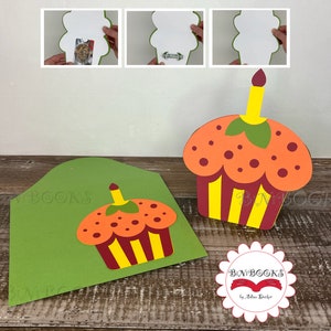 Pode incluir: Um cartão verde com um desenho de cupcake. O cupcake é laranja, amarelo e vermelho com uma vela acesa no topo. O cartão está dobrado ao meio e tem um rótulo branco na frente que diz "BN'BOOKS by Allison Becker".