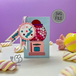 Könnte beinhalten: Eine rosa und blaue Gummibärchen-Maschine mit einem Etikett, auf dem "You're so sweet" steht. Die Gummibärchen-Maschine ist eine digitale Schnittdatei zum Basteln.