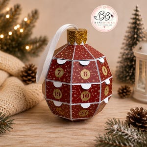 May include: A red, multi-faceted, spherical advent calendar ornament featuring gold-colored numbers from 1 to 24 on small flaps. The ornament has a gold glitter top cap with a white ribbon loop for hanging and a pattern of white candy canes.