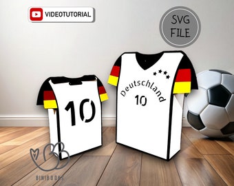 May include: A printable SVG file for a soccer jersey box. The box is white with black trim and features the German flag on the sleeves. The text "Deutschland" and the number "10" are printed on the front of the box.