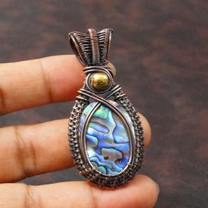 Handgemaakte hanger van abalone schelp en koper, met draad omwikkelde ketting.