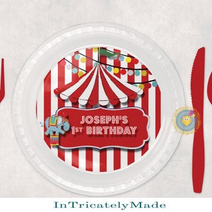 May include: Red and white striped paper plate with a circus tent design and a banner that says "Joseph's 1st Birthday".