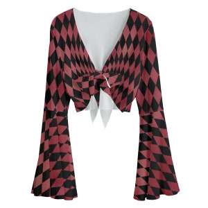 Op de afbeelding: Een rood en zwart geruit crop top met een strik aan de voorkant en lange bell sleeves.