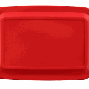 May include: A bright red rectangular baking dish with a slightly raised rim and handles on each side. The dish has a smooth, matte finish and appears to be made of silicone or a similar material. The overall design is simple and functional.
