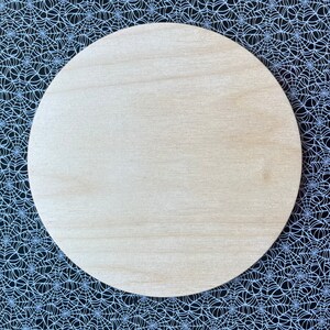 May include: A round, unfinished wooden circle, perfect for crafting projects. The circle is light brown and has a smooth surface.