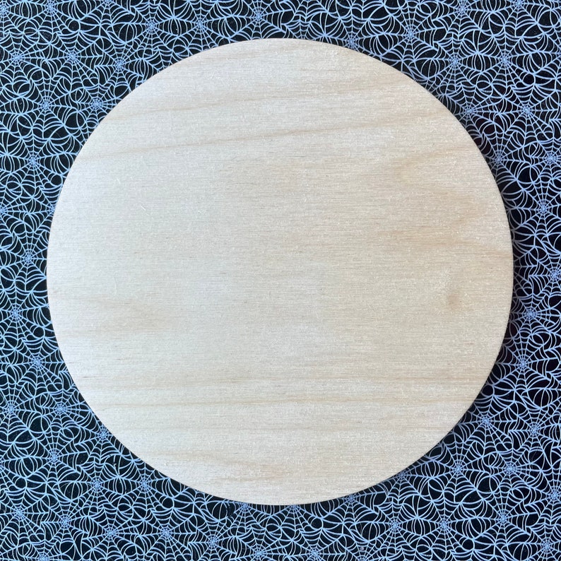May include: A round, unfinished wooden circle, perfect for crafting projects. The circle is light brown and has a smooth surface.