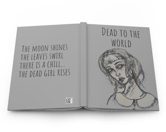 Può includere: Un diario con copertina rigida con una copertina grigia. Il lato sinistro ha il testo "THE MOON SHINES THE LEAVES SWIRL THERE IS A CHILL... THE DEAD GIRL RISES". Il lato destro ha il testo "DEAD TO THE WORLD" e uno schizzo di donna.