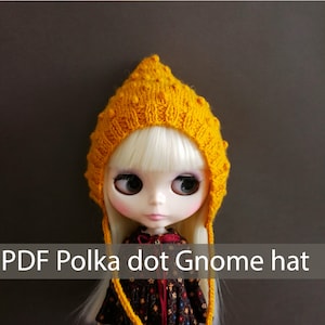 Può includere: Un cappello da gnomo di lana gialla con pois. Il cappello ha un lungo laccio che può essere legato sotto il mento.  PDF Cappello da gnomo a pois.