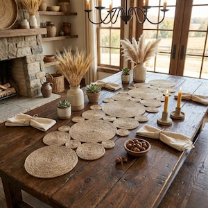 Può includere: Un tavolo da pranzo rustico apparecchiato per un pasto. Il tavolo in legno scuro presenta un runner in juta, sottobicchieri abbinati e tovaglioli beige. Vasi decorativi con grano e pampas, candele e piccole piante in vaso completano l'allestimento.