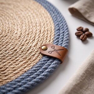 Denim blue striped oval jute placemat paired with a round woven mat on a rustic wooden table setting.