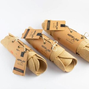 Three rolled jute wall panels wrapped in kraft paper and tied with cord, each with a Homever handmade tag, ready for shipping
