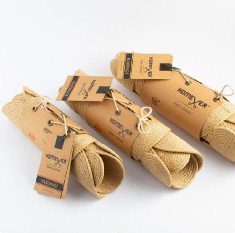 Three rolled jute wall panels wrapped in kraft paper and tied with cord, each with a Homever handmade tag, ready for shipping