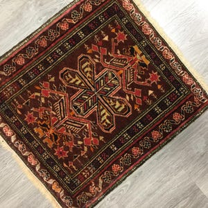 May include: A traditional Turkish rug with a brown background and intricate geometric patterns in shades of red, orange, green, and black. The rug has a fringed border.