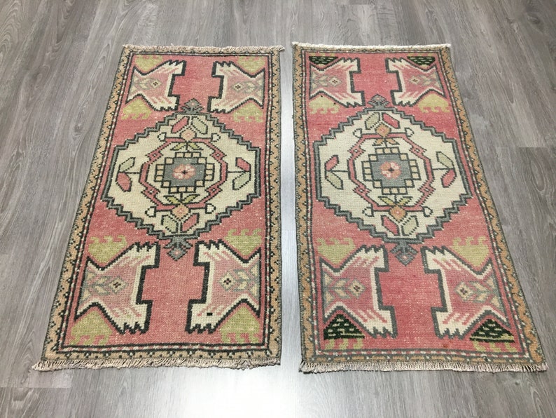 May include: Two pink and beige patterned runner rugs with a geometric design. The rugs have a fringe border.