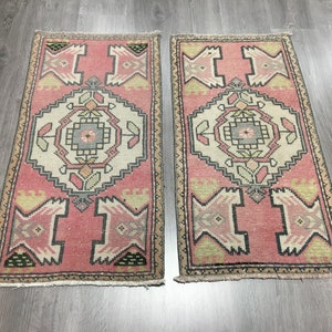 May include: Two pink and cream patterned runner rugs with a geometric design. The rugs have a fringe border.