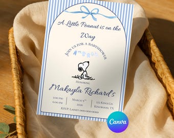 Puede incluir: Una tarjeta de invitación rectangular para baby shower con un borde de rayas verticales en azul claro y blanco. El centro presenta un diseño arqueado con una cinta azul, el texto A Little Peanut is on the Way, una ilustración de Snoopy.
