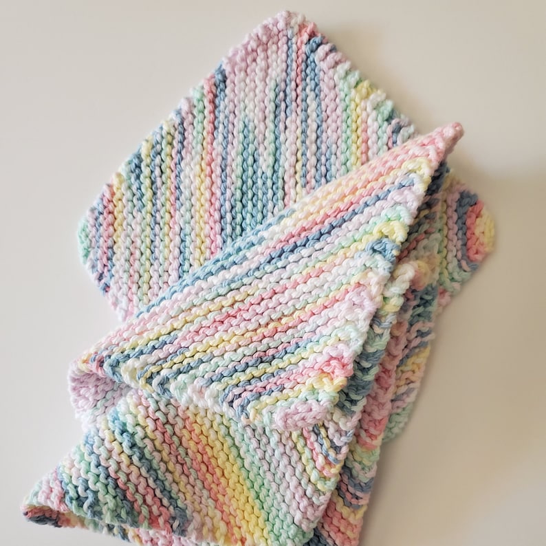 May include: A soft, multi-colored knitted baby blanket with stripes of pink, blue, yellow, and green.
