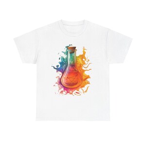 Könnte beinhalten: Ein weißes T-Shirt mit einer zentralen Grafik eines Glasfläschchens mit Korkstopfen. Das Fläschchen enthält eine leuchtend orangefarbene Flüssigkeit, umgeben von einem lebendigen, mehrfarbigen Farbspritzer in Blau, Gelb, Rot und Violett.