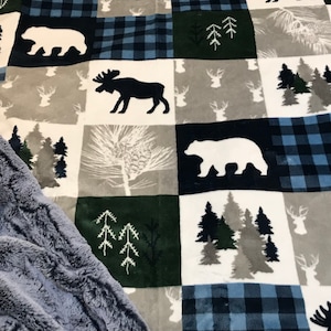 May include: A soft, plush blanket with a patchwork design featuring a variety of woodland animals and trees. The blanket is made of a soft, fuzzy material and is perfect for cuddling up on the couch.
