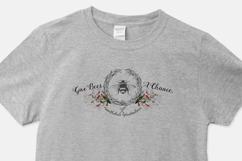 May include: Gray t-shirt with a graphic design of a bee in a wreath with the text "Give Bees A Chance. save the bees plant flowers"