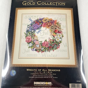 Puede incluir: Kit de punto de cruz contado The Gold Collection Wreath of All Seasons de Dimensions. El paquete muestra un diseño de corona floral con motivos estacionales y las palabras Summer, Winter, Spring y Fall. Incluye tela Aida marfil de 18 ct.