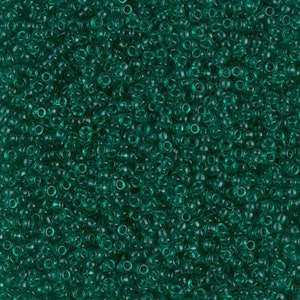May include: A close-up view of a large quantity of small, round, transparent green beads. The beads are arranged in a random pattern, creating a textured surface.