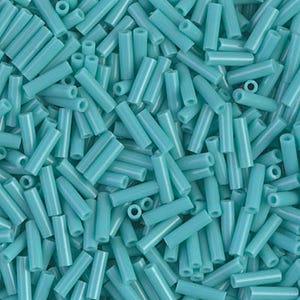 May include: A close-up shot of a pile of light blue cylindrical beads. The beads are uniform in size and shape, with a hollow center. The surface of the beads appears smooth and slightly glossy. The beads are scattered randomly, creating a dense, textured pattern.