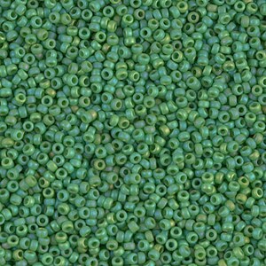 May include: A close-up image of a large quantity of small, round, green glass beads. The beads have a slightly iridescent finish.
