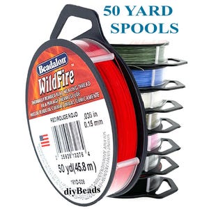 May include: A stack of Beadalon WildFire thermally bonded bead weaving thread on 50 yard spools. The front spool is red, with labels showing 0.006 inch diameter. The stack includes green, blue, frost, beige, pink, grey, black, and red thread colors.