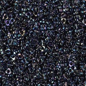 May include: A close-up of a pile of small, iridescent black beads. The beads are shaped like a teardrop with a small hole at the top. The beads have a metallic sheen and are scattered randomly.
