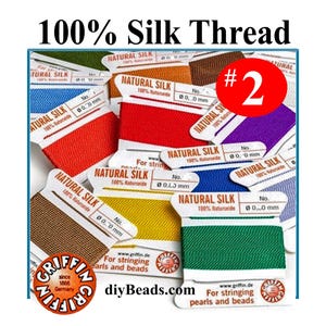 May include: A collection of Griffin brand 100% natural silk thread spools in various colors including red, yellow, green, blue, brown, and purple. Each spool is labeled Natural Silk, includes an attached needle, and is for stringing pearls and beads.